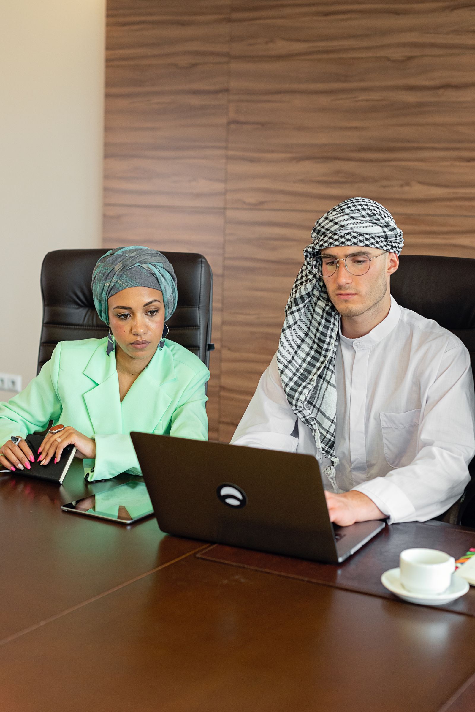 Professionals in traditional attire reviewing information together
